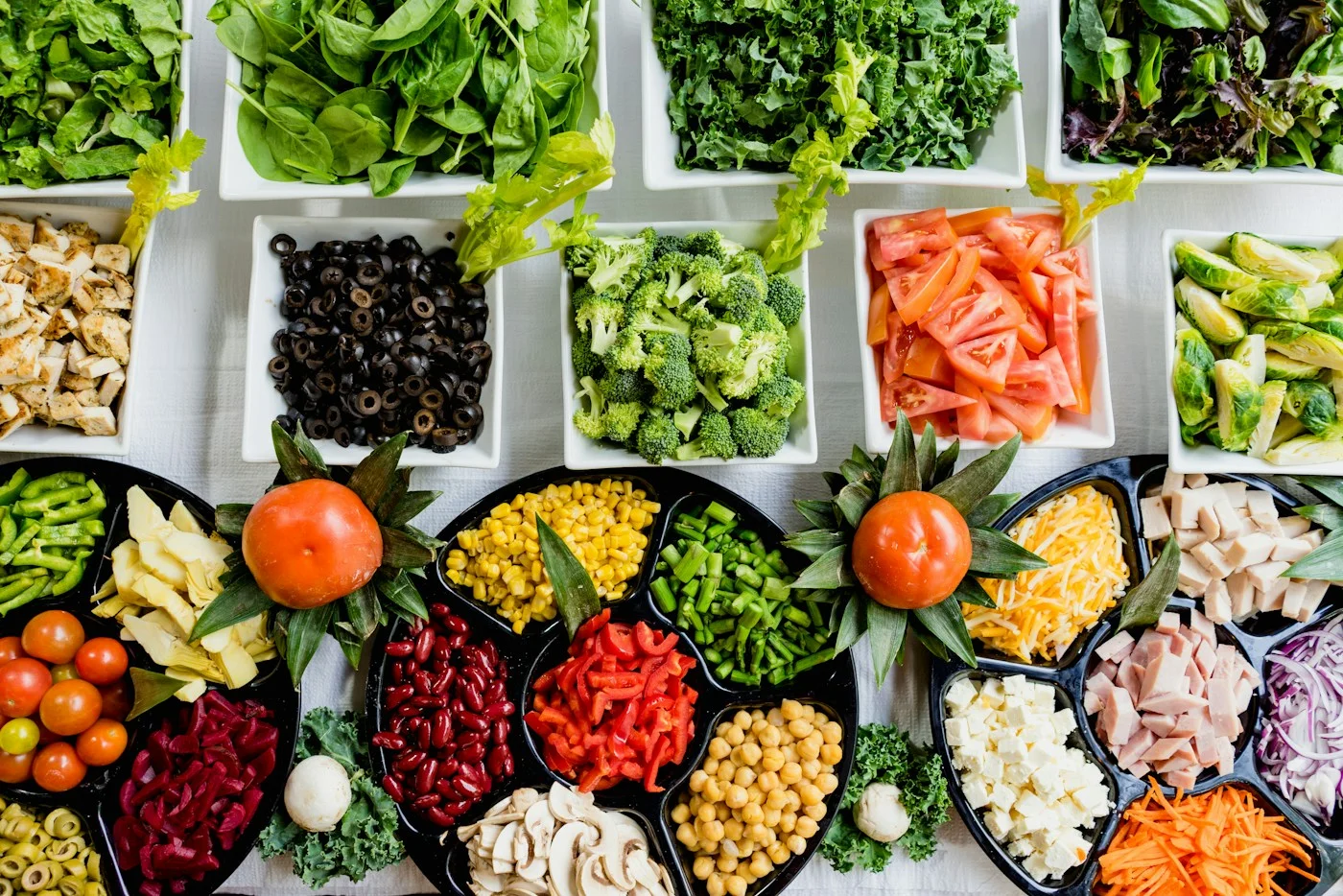 A market display of leafy greens and colorful fresh vegetables.